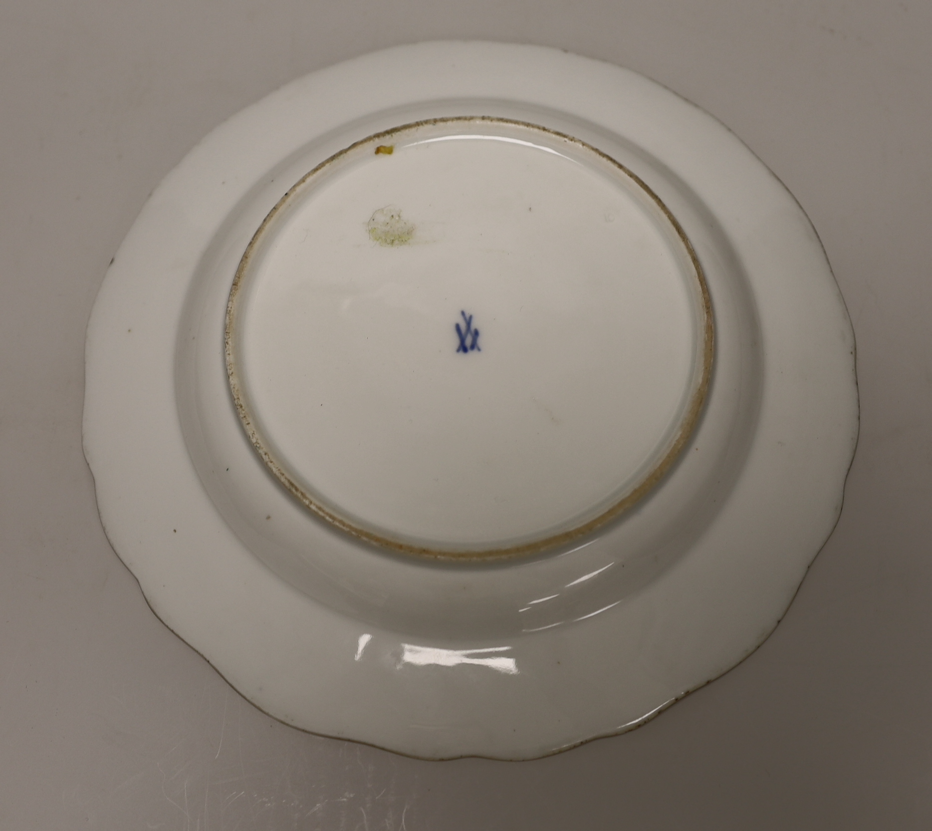 A Meissen plate with crown and fish crest boldly painted with flowers, crossed swords in blue, and four smaller plates painted with birds, probably 19th century German, 24cm in diameter